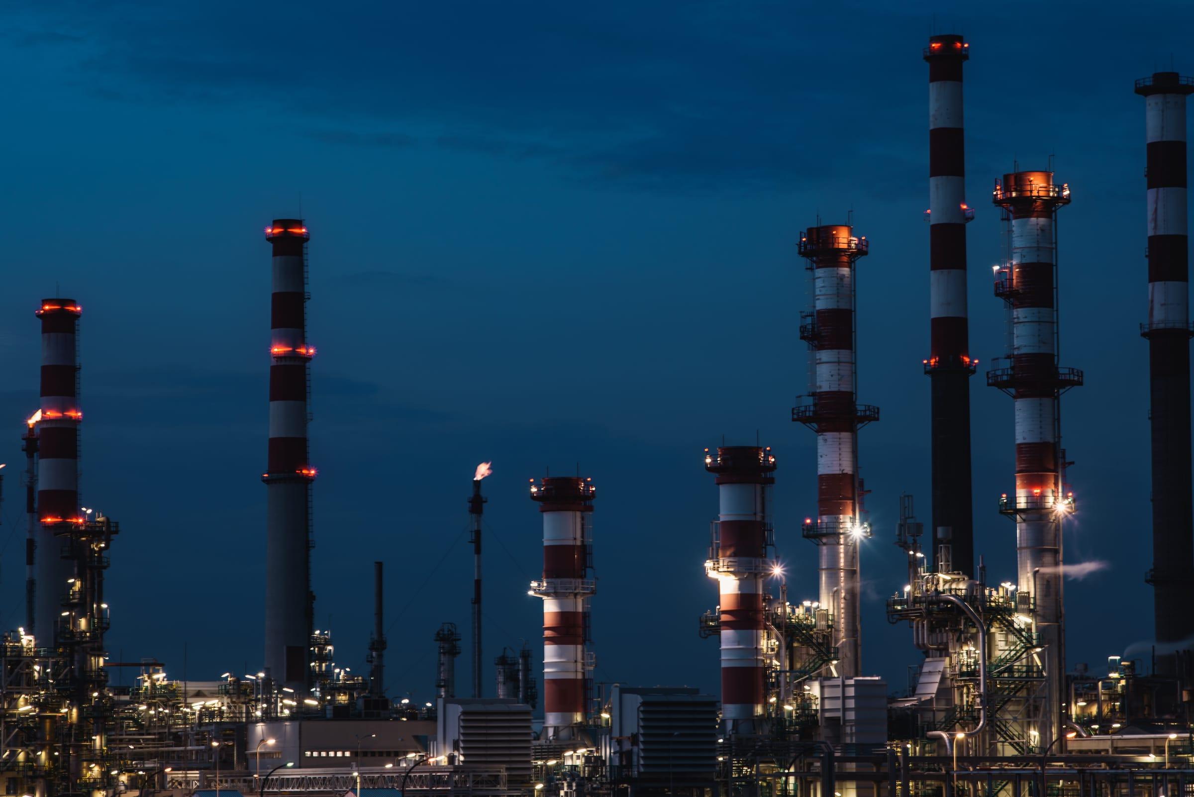 Refinery stacks and process units at dusk