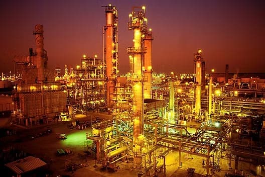 An oil and gas processing plant lit at dusk